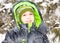 Close up portrait of adorable happy little boy grinning happily at the camera on a sunny winter`s day