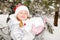 Close up portrait of adorable happy little girl grinning happily at the camera on a sunny winter`s day