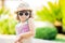 Close-up portrait of adorable little girl at the tropical resort, palm trees at the background, sunny summer day