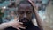 Close up portrait of an African American against a mirrored wall the hands of a European woman gently touch the face of