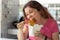 Close-up portrait of an amusing crazy young pretty girl eating chinese noodles with wooden chopsticks sitting in a cafe