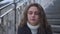 Close-up portrait of anxious stressed young beautiful woman thinking sitting on urban stairs on spring autumn day