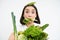 Close up portrait of asian girl munching lettuce leaf, holding green oranic vegetables, leads healthy lifestyle with