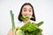 Close up portrait of asian girl munching lettuce leaf, holding green oranic vegetables, leads healthy lifestyle with