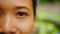 Close-up portrait of asian girl opening eye sensually, slowly. Looking at camera