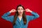 Close-up portrait of attractive crazy desperate girl closing ears isolated over bright red color background