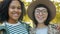 Close-up portrait of attractive ladies Afro-American and Caucasian smiling outdoors