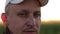 close up portrait of attractive man staring looking intense eyes. farmer close up. man in a white baseball cap. look of