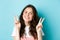 Close up portrait of attractive positive girl saying cheeze, smiling and showing v-signs peace, standing over blue