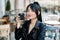 Close-up portrait of attractive stylish smiling Asian girl with brunette ponytail hair, wearing casual black leather