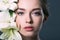 close-up portrait of attractive young woman surrounded with white lilium flowers