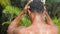 Close up portrait of the back of a young black masculine man taking showe outdoor.