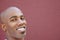 Close-up portrait of bald African American man over colored background