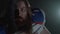 Close-up portrait of a bearded american football player with long hair and beard in sports equipment shouting looking in