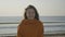 Close up portrait of a beautful young girl smiling on the beach while wind blows her hair -