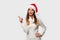 Close up portrait beautifiul caucasian woman in red Santa hat on white studio background. Christmas and New Year holiday concept