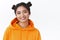 Close-up portrait of beautiful asian girl with cute two hairbuns, wearing orange stylish hoodie, smiling happy express