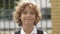 Close up portrait of beautiful , attractive , caucasian curly hair boy with Backpack. School child looking and smiling