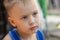 Close up portrait of beautiful baby boy with serious look and Herpes infection on the low lip.