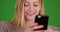 Close-up portrait of beautiful blonde millennial woman on green screen