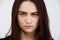 Close up portrait of beautiful brunette girl starring with anger in camera