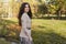 Close up portrait of a beautiful brunette teen girl with make up and in elegant fall outfit, posing in the park.