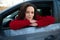 Close-up portrait of a beautiful confident Hispanic woman, female driver sitting on a driver seat and confidently looking at