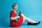 Close up portrait of beautiful dollish girl with short light violet hair wearing red dress holding ukulele over blue