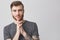 Close up portrait of beautiful happy caucasian man with beard,fashionable hairstyle and tattooed arm wearing grey shirt