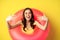 Close up portrait of beautiful happy woman inside pink swimming ring, luring, inviting people on summer vacation, beach