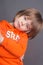 Close-up portrait of beautiful little boy four years old, wearing a orange hoodie