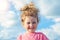Close up portrait of beautiful little girl, happy child. Positive kid outdoors looking at camera on the blue sky background