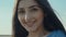 Close up portrait of beautiful long hair caucasian woman smiling on camera on crop fields background in slow motion