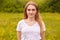 Close up portrait of beautiful young caucasian woman resting in nature, poses isolated over meadow background, cute female looking