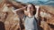 Close up portrait of beautiful young woman in nature with brunette hair blowing in wind looking at mountain view Hiker