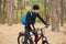 Close up portrait of biker riding on his bike in autumn or spring inspirational forest landscape, handsome young man cycling on