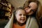 Close-up portrait of blond funny little girl with her mother in festive interior with garlands