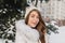 Close-up portrait of blue-eyed girl with snow in hair enjoying happy winter time. Outdoor photo of sensual blonde woman