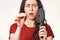 Close up portrait in a blur, a frightened brunette woman holds a comb in her hands, clearing it from a pile of fallen hair. White