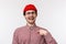 Close-up portrait boastful funny bearded young man in red beanie and glasses, pointing at himself as talking own