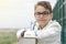 Close up portrait of a boy with glasses wearing a white sailor suit for his first communion. Sea at the background