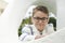 Close up portrait of a brunette boy whit glasses wearing a fashion white sailor suit for his first communion