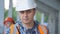 Close-up portrait of a Builder or engineer in a construction helmet on a construction site communicating with his