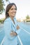 Close up portrait of business woman smiling while standing with arms crossed on a athletics court