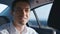 Close-up Portrait of Businessman Traveling in a Car with a Driver. Smiling Young Man in white shirt rides in a Taxi