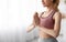 Close up portrait of calm peaceful european cute young blonde lady practicing yoga at home on large window background