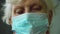 Close up portrait of caucasian blonde old woman in protective mask on her face. Epidemic of influenza virus and