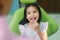 Close up portrait of a caucasian girl having an examination at the pediatric dentist while smiling at camera