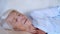 Close up portrait of caucasian happy calm elderly woman sleeping or relax on comfortable sofa at home. taking nap or