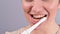 Close-up portrait of caucasian woman brushing her teeth with an electric toothbrush. The girl performs the morning oral
